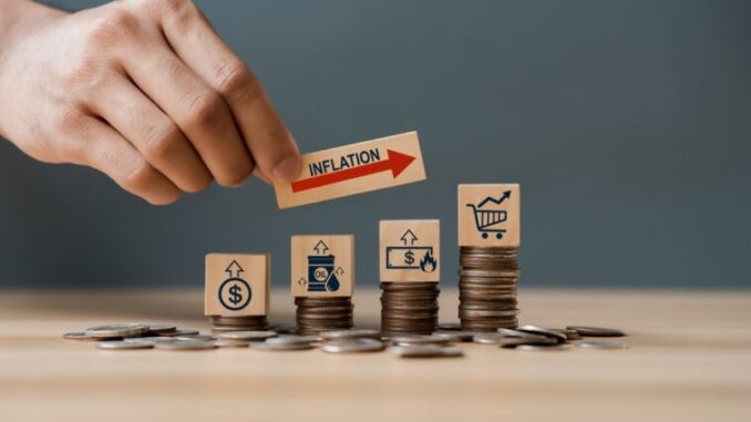 Hand,Putting,Wooden,Cube,And,Inflation,Word,A,On,Coins