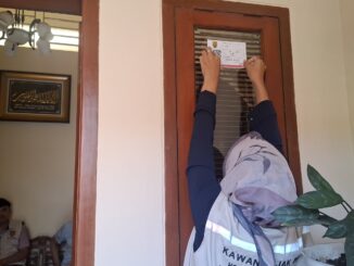 Petugas pajak Semarang memasang stiker IQRO pada bangunan sebagai bagian digitalisasi pajak daerah.