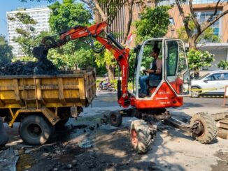 Petugas DPU membersihkan sedimen drainase Simpang Lima untuk mencegah genangan air.