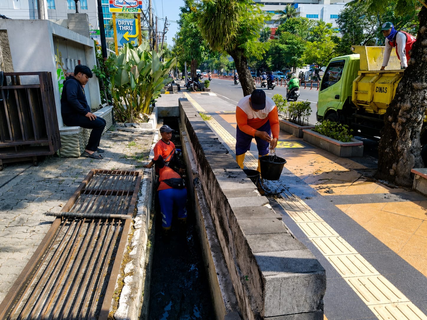 Petugas DPU membersihkan sedimen drainase Simpang Lima untuk mencegah genangan air.