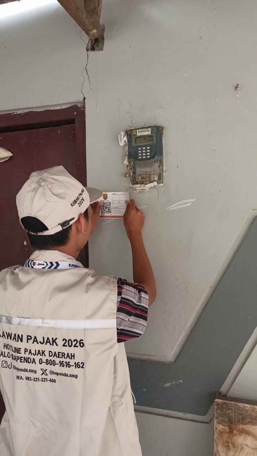 Petugas pajak Semarang memasang stiker IQRO pada bangunan sebagai bagian digitalisasi pajak daerah.