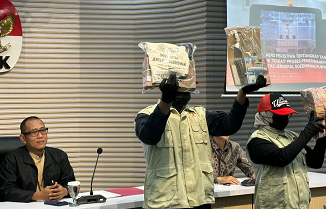 Pelaksana Tugas Direktur Penyidikan Komisi Pemberantasan Korupsi Achmad Taufik Husein (kiri) mempersilakan dua petugas menunjukkan barang bukti kasus dugaan korupsi dalam penerimaan mahasiswa baru Universitas Jenderal Soedirman (Unsoed), di Gedung Merah Putih KPK, Jakarta, Jumat (21/8/2026). (ANTARA FOTO)